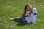 Girl Sitting In The Meadow Stock Photo