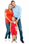 Mother, Father And Cute Daughter Posing In Trendy Outfits Stock Photo