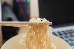 Some People Eat Noodles During Work Stock Photo