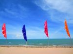 Multicolored Flag On The Beach With Blue Sky And Blue Sea Stock Photo