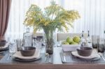 Glass Vase Of Flower On Dinning Table With Table Set Stock Photo