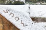 Word Snow On Lying Tree Trunk In Nature Stock Photo