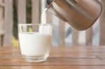 Pour Milk From A Pitcher Into A Glass Stock Photo