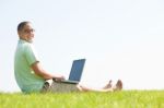 A Young Men Sit On The In The Park Using A Laptop Stock Photo