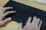 Hands Type On Keyboard With Wooden Table Stock Photo