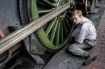 Young Man Cleaning A Steam Train Wheel Stock Photo