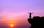 Silhouette Of A Man On The Rock At Sunset Stock Photo