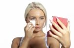 Young Woman Clean Face With Wet Wipes, Looking On Mirror In Hand Stock Photo