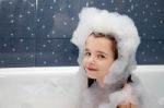 Little Girl Sitting In A Bath With Soap Suds Stock Photo