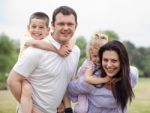 Parents Piggy Backing Kids Stock Photo