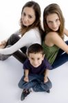 Young Kid Sitting With Teenagers Stock Photo