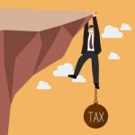 Businessman Try Hard To Hold On The Cliff With Tax Burden Stock Photo