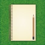 Notebook With White Page On Green Grass Background Stock Photo