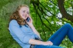 Dutch Teenage Girl Phoning Mobile In Green Tree Stock Photo