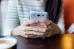 Young Beautiful Woman Using Her Mobile Phone In Coffee Stock Photo