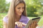 Beautiful Woman With Tablet Computer In Park Stock Photo