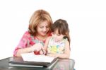 Mother And Daughter Doing Homework At Home Stock Photo