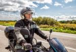 Elderly Motorcyclist Wearing A Jacket And Glasses With A Helmet Stock Photo