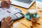 Business Man Sitting On A Calculator To Figure Out In A Coffee S Stock Photo