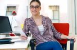 Beautiful Young Woman Using Her Mobile Phone In The Office Stock Photo