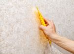 Man's Hand Smoothing The Wallpaper With A Spatula Stock Photo