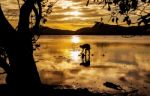 Silhouette Fisherman In Frame From Nature With Sunset Stock Photo