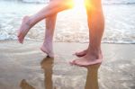 Young Couple Legs On The Beach Sand Stock Photo