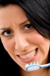 Close Up Of Woman Brushing Her Teeth With White Background Stock Photo