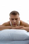 Young Man Relaxing On Bed Stock Photo