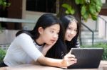 Two Asia Thai High School Student Best Friends Beautiful Girl Using Her Tablet And Funny Stock Photo