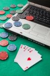 Poker Chips And Cards And A Laptop On Casino Baize Stock Photo