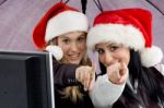 Colleagues Wearing Christmas Hat And Pointing Towards Stock Photo