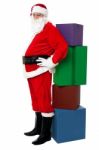 Santa Leaning Over Colorful Pile Of Xmas Presents Stock Photo