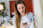 Beautiful Young Woman Using Her Mobile Phone In The Office Stock Photo