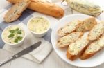 Baguette With Herb Butter And Rosemary Thyme On Rustic Wooden Background Stock Photo