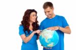 Smiling Young Couple Holding Globe Stock Photo