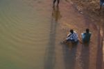 Friends Sitting On Stones Near The Shore Of The Bharatha River Stock Photo