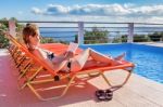 Caucasian Woman Sunbathing And Reading Book Stock Photo