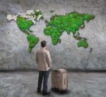 Young Man Standing And Looking To World Map On Wall Stock Photo