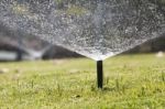 Sprinkler Head Watering In Park Stock Photo