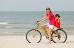 Asian Son And Mother Riding Bicycle On Beach Stock Photo