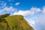 People Hiking To Top Of Mountain With Blue Sky Stock Photo