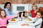 Family Raising Their Glasses Before Eating Stock Photo