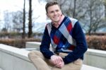 Stylish Young Man Sitting In Sidewalk Stock Photo