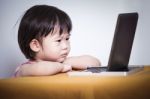 Serious Child Sitting And Looking A Story On Touchscreen Digital Stock Photo