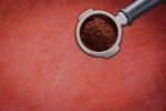 Coffee Grind In Group On Red Concrete Background Stock Photo