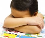 Child Sleeping On Educational Desk Stock Photo