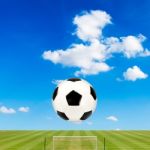 Soccer Ball With Soccer Field Against  Blue Sky Background Stock Photo