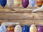 Easter Eggs And Bird Feathers On Wood Background With Space Stock Photo