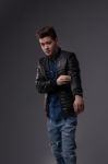 Casual Young Man In Black Leather Jacket And Denim Jeans Stock Photo